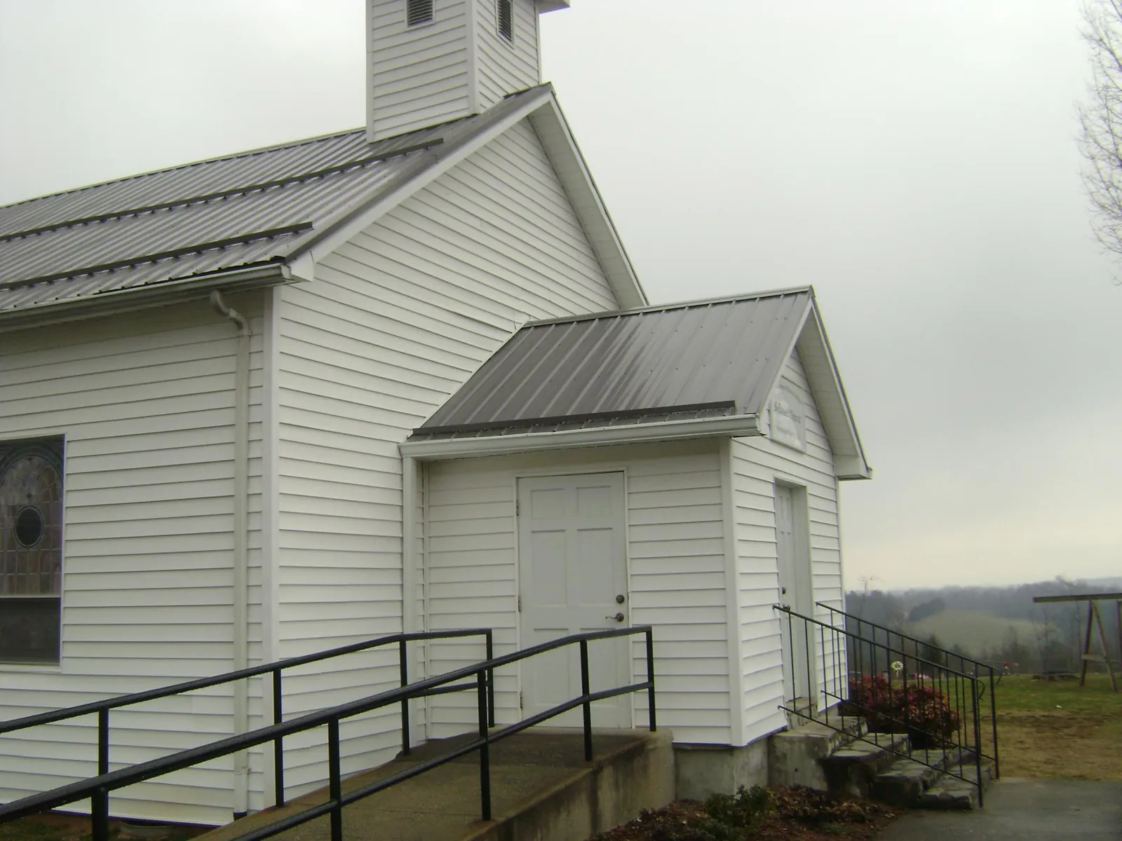 Gray metal roof on a white clapboard church with a steeple in Petersburg